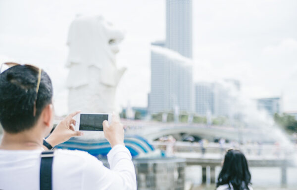 海外旅行でスマホを使っている男性