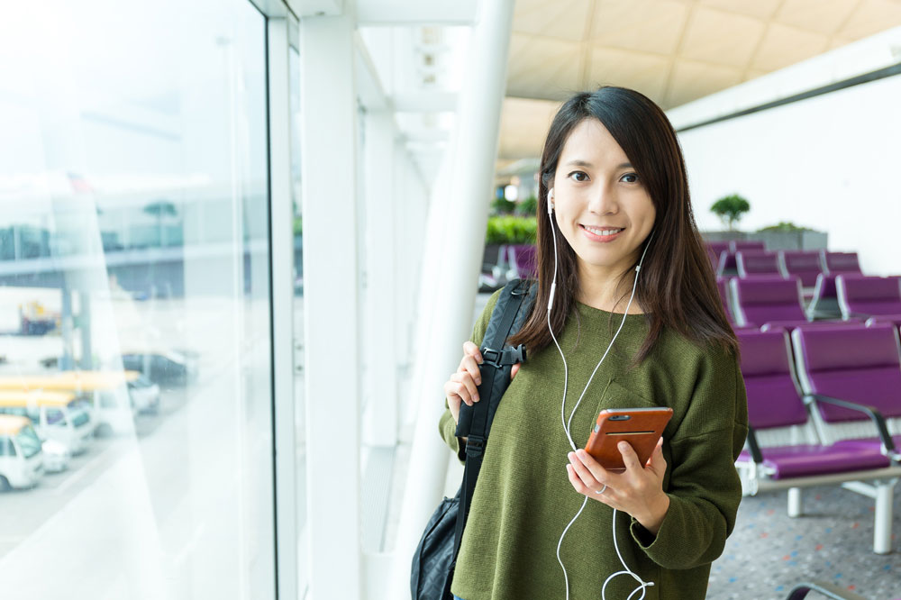 海外旅行でスマホを使い満足する女性